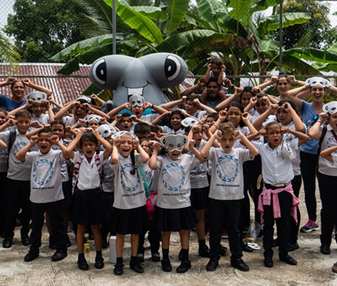 Local schoolchildren standing near a hammerhead shark mascot