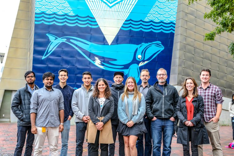 group of eleven people standing outside the aquarium