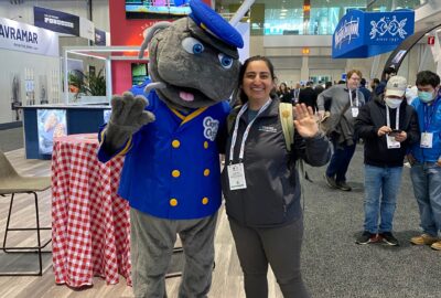 woman standing next to a costumed character of a catfish