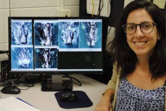 Woman next to a computer screen showing right whale photos