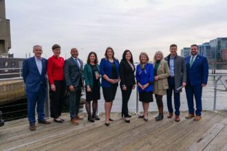 Aquarium President and CEO Vikki Spruill and press conference attendees along the waterfront.