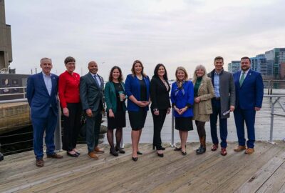 Aquarium President and CEO Vikki Spruill and press conference attendees along the waterfront.