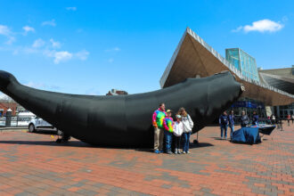 Visitors pose with Calvin, an inflatable right whale