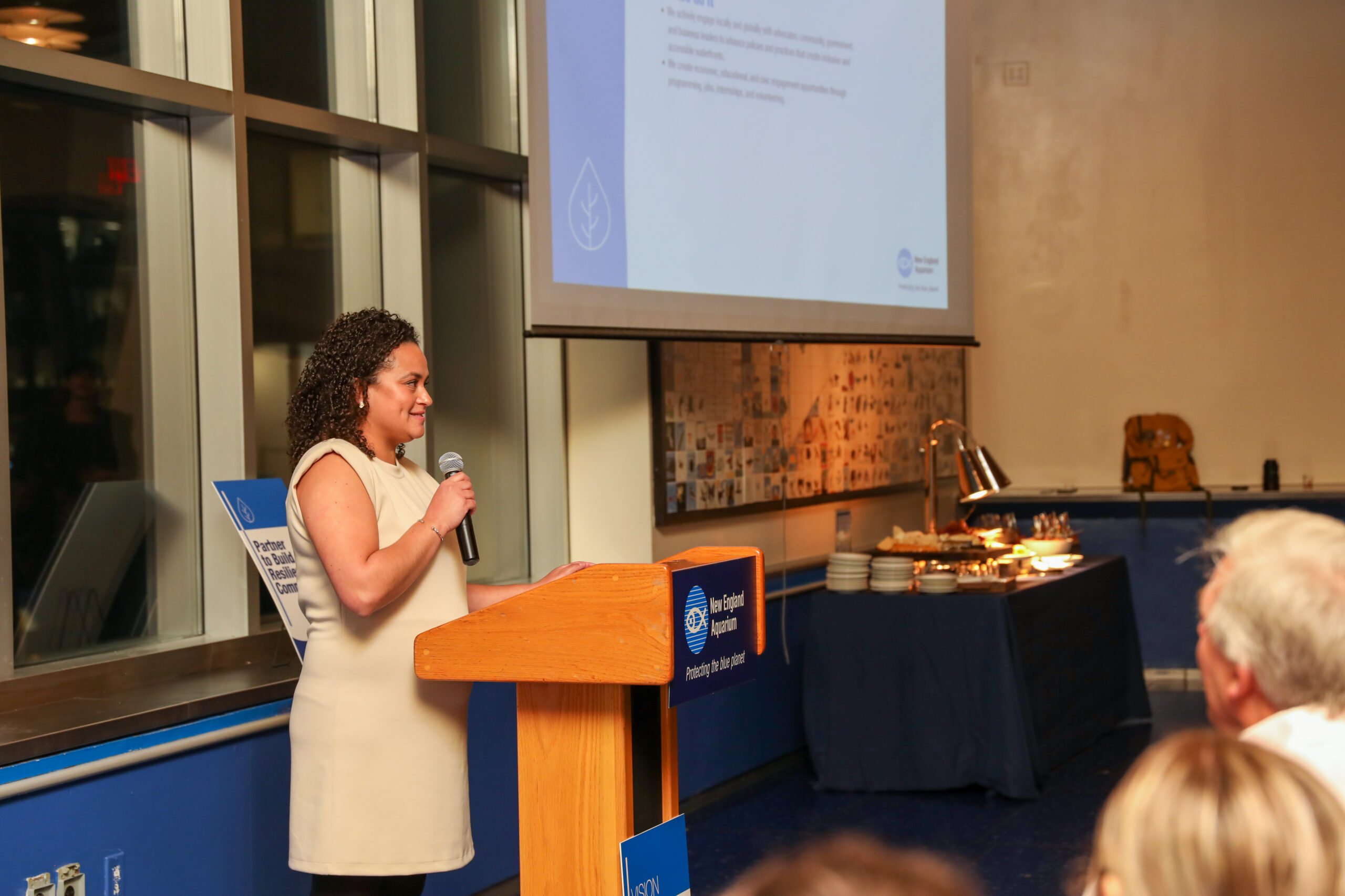 Luz Arregoces welcomes community members to an event. 