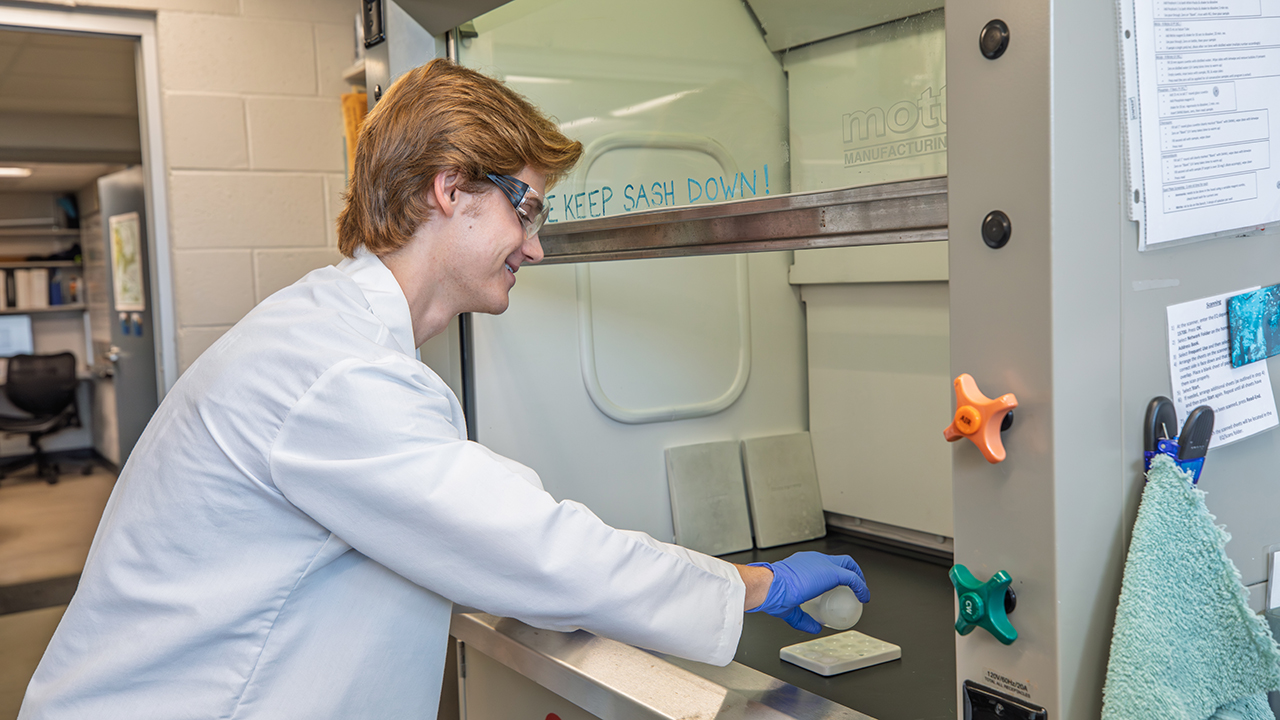 A person in a lab coat working in a laboratory space
