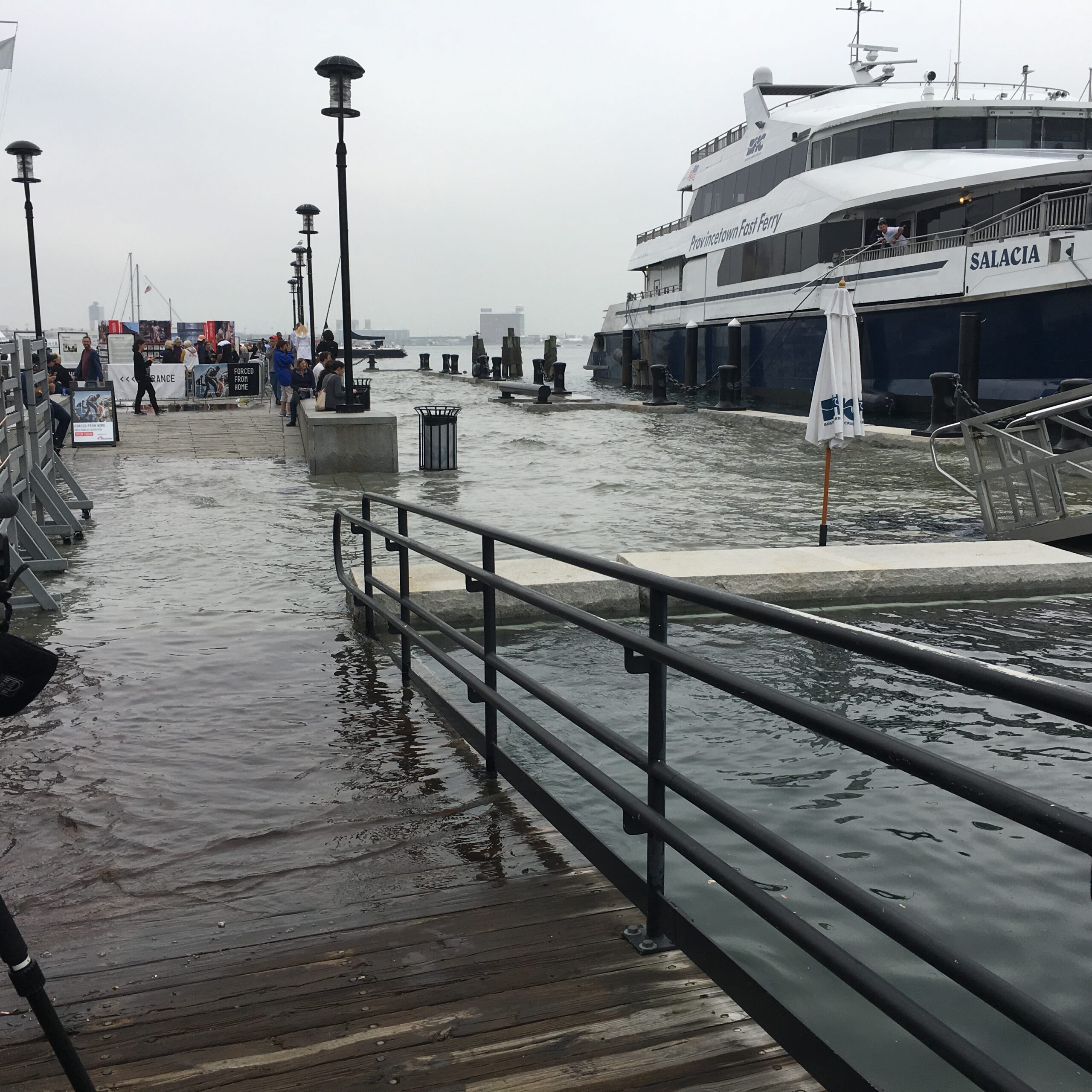 Flooding along a pier with a ferry visible in the background