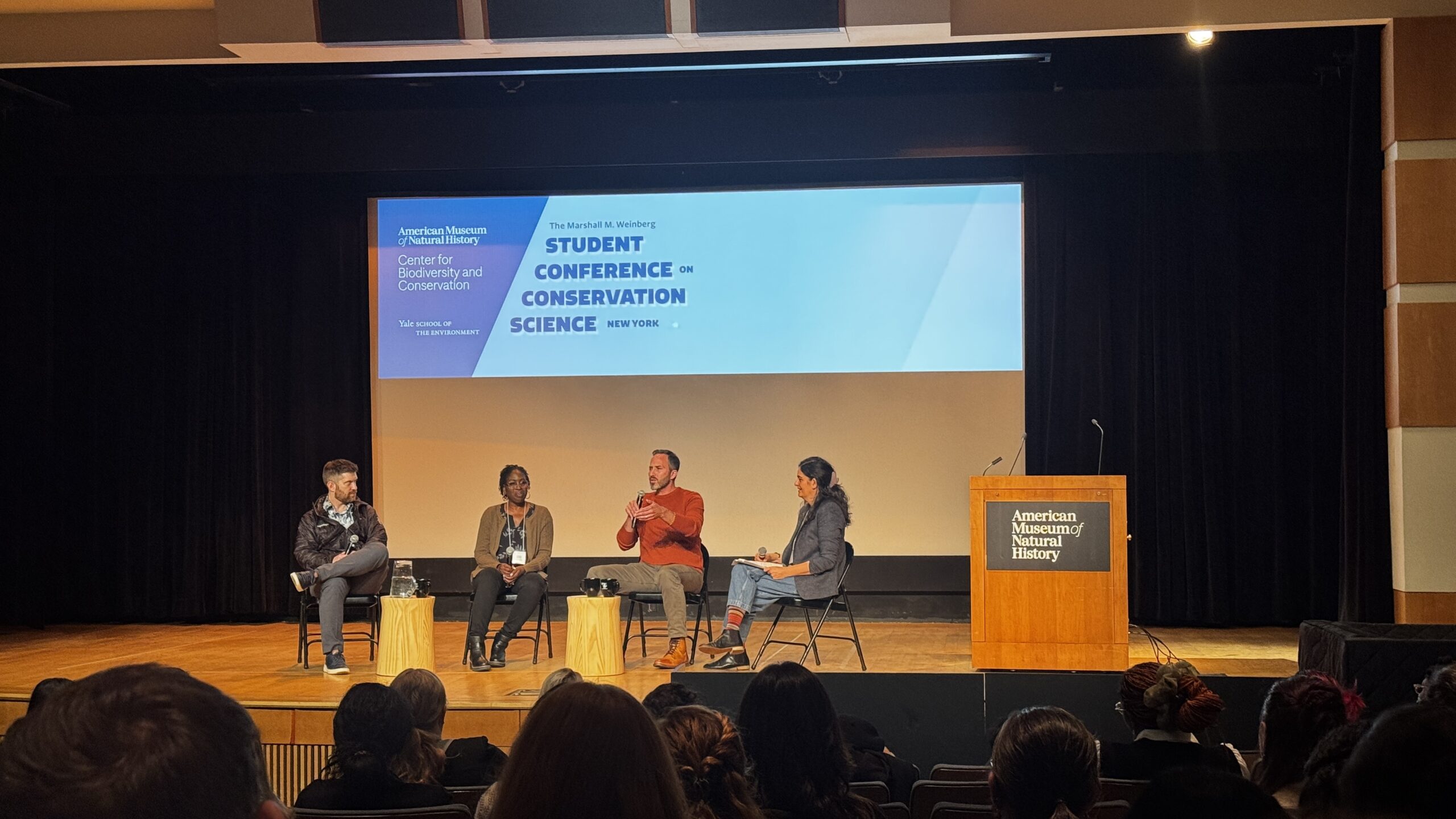 Four people sit on stage for a panel.