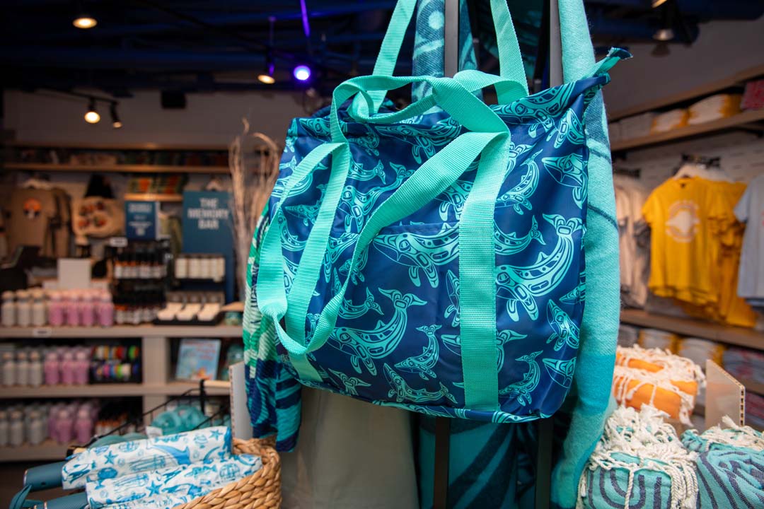 Colorful tote bag with sea creature pattern on display in a retail store.