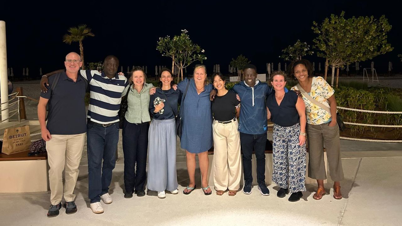 A group of people posing together for a photo outdoors at night