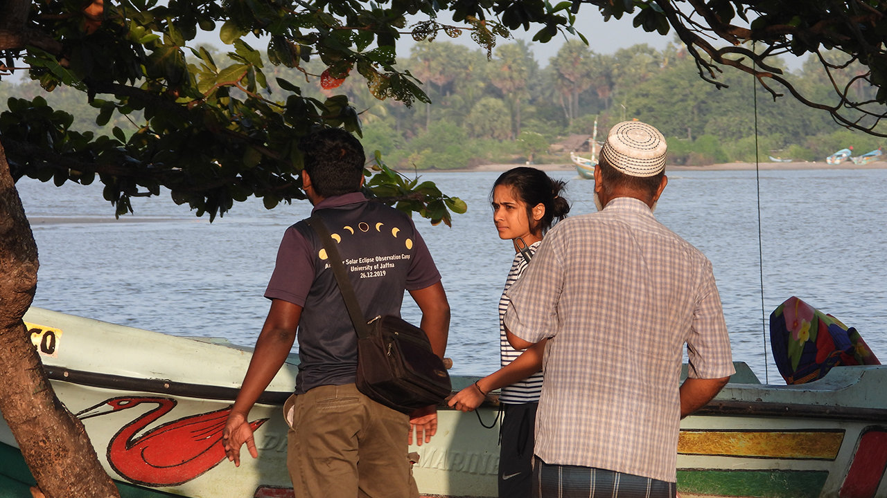 People gathered near a traditional boat