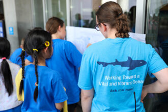 A staff member talking with a young guest at an event at the Aquarium