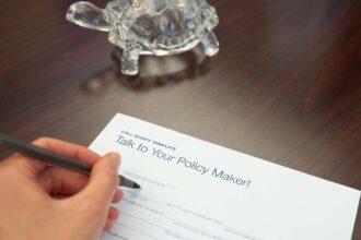 A person writing a letter on a desk