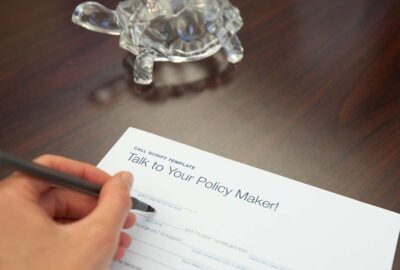 A person writing a letter on a desk
