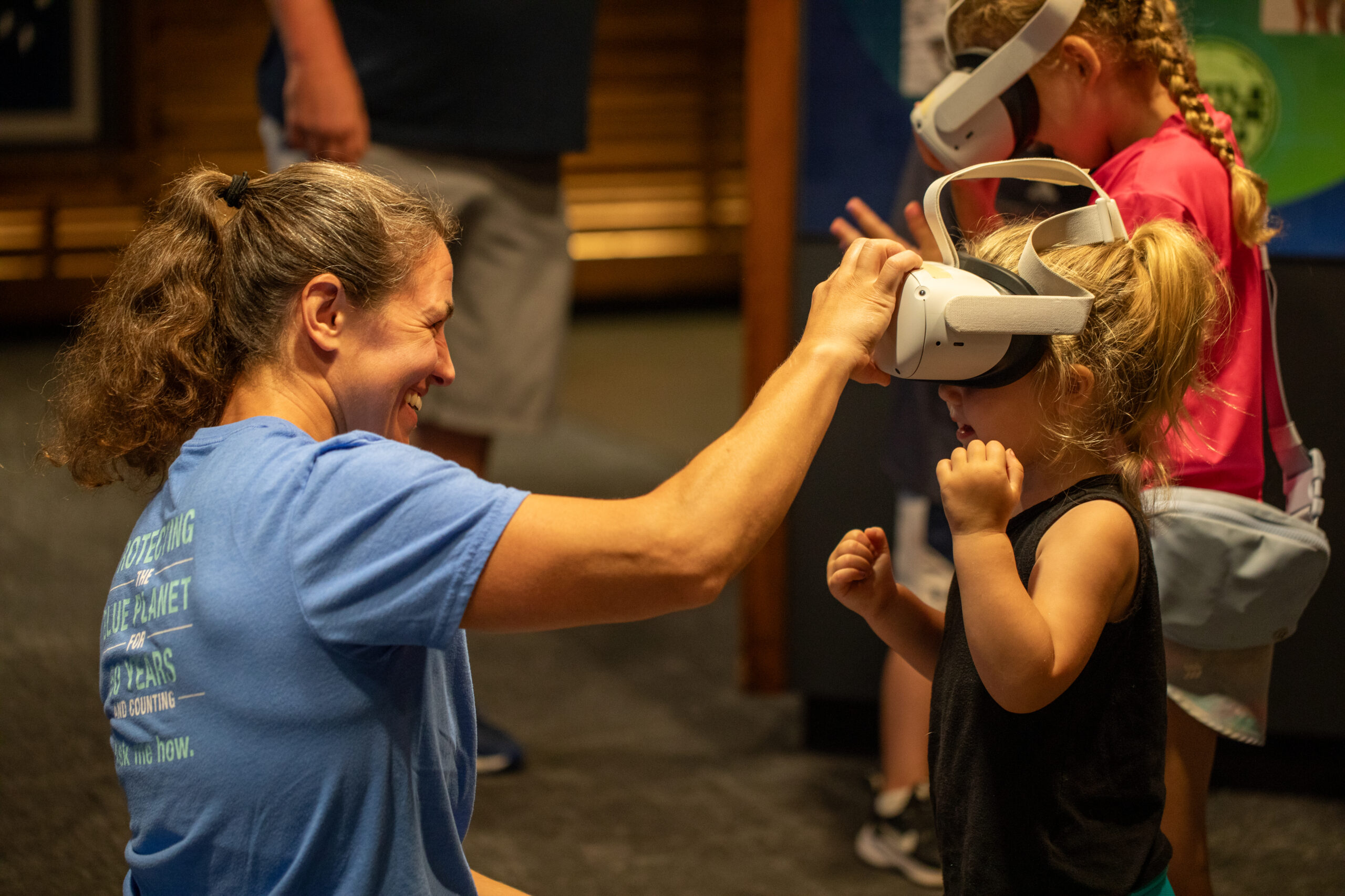 Emily Jones interacts with a young guest experiencing virtual reality