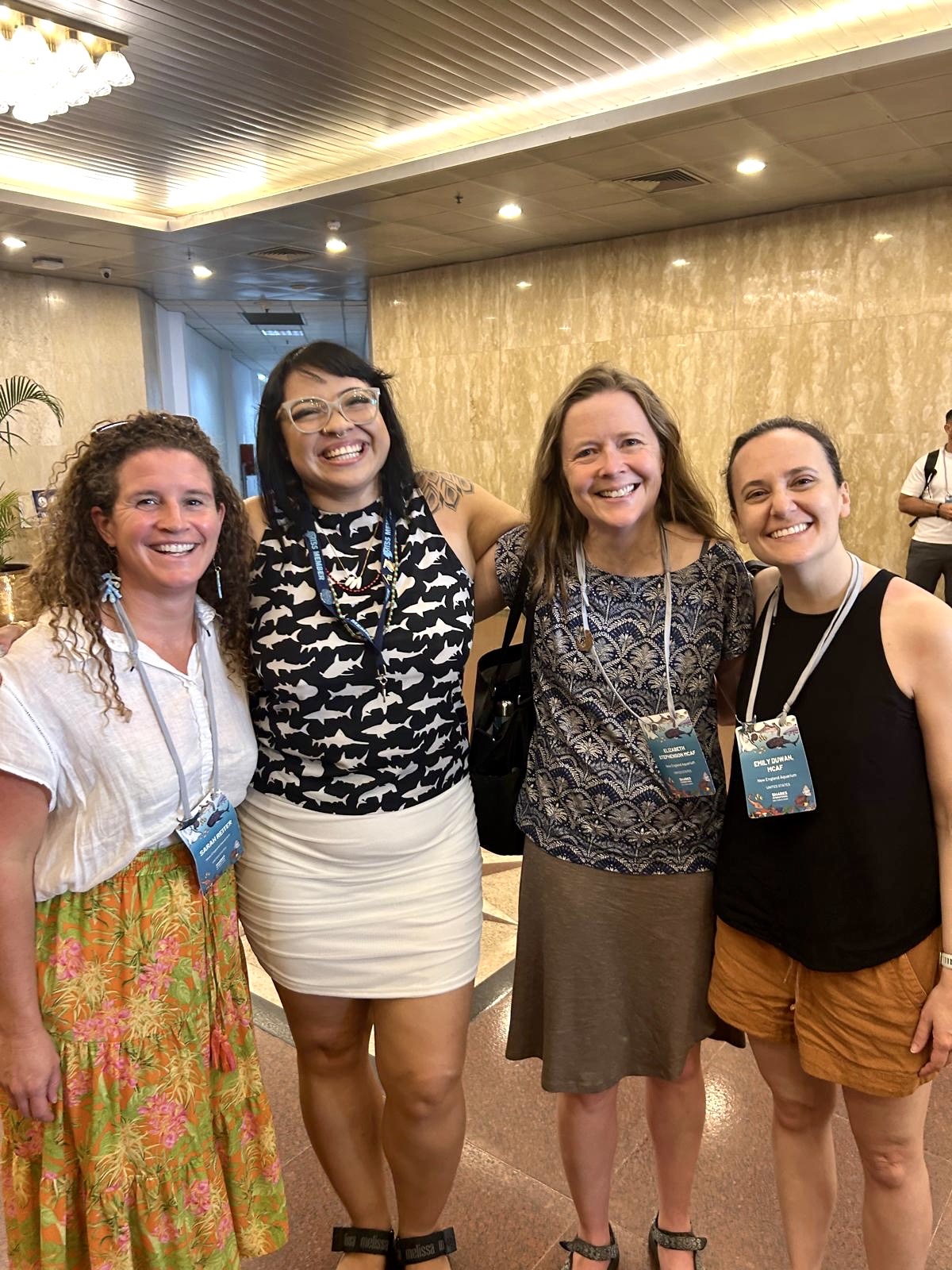 A group of four people posed together for a photo in a conference setting
